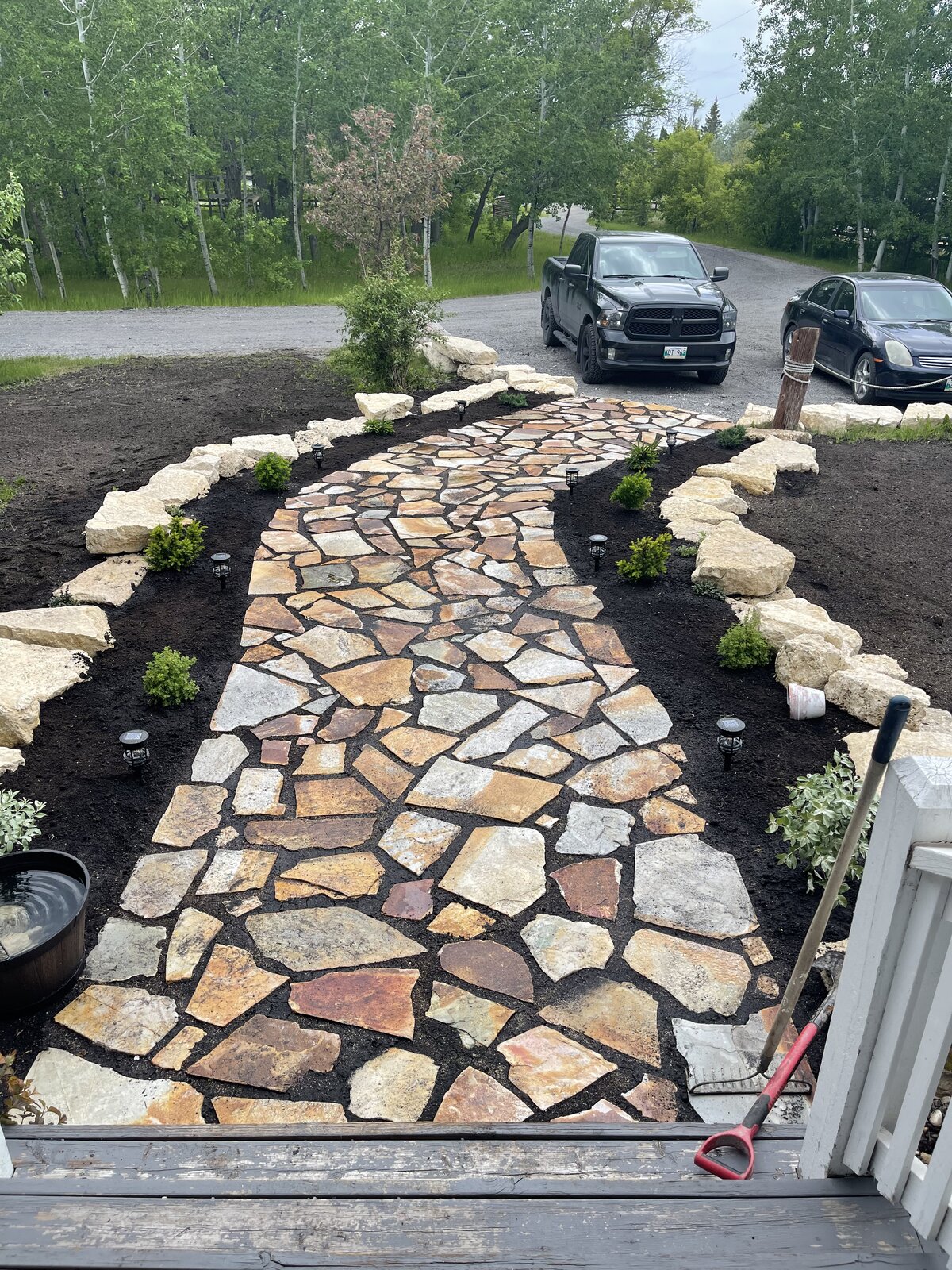 Natural flagstone walkway with limestone border and landscape lighting in Manitoba