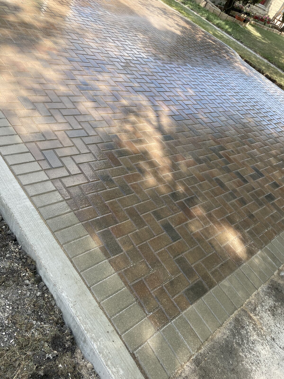 Herringbone-pattern brick paver driveway with soldier-course border in Winnipeg