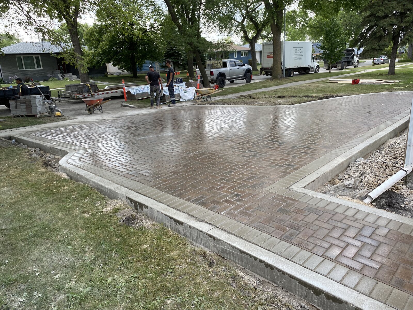 New paver driveway with concrete curb being installed by Iberica Construction crew in Winnipeg